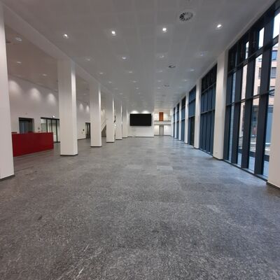 Boden- und Wandflächen mit großformatigen Fliesen im Atrium des Kreishauses Bergheim