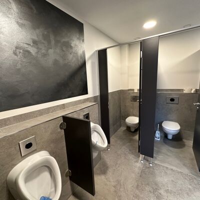 Sanitärbereich der Gemeindehalle Anschau mit großformatigen Wand- und Bodenfliesen